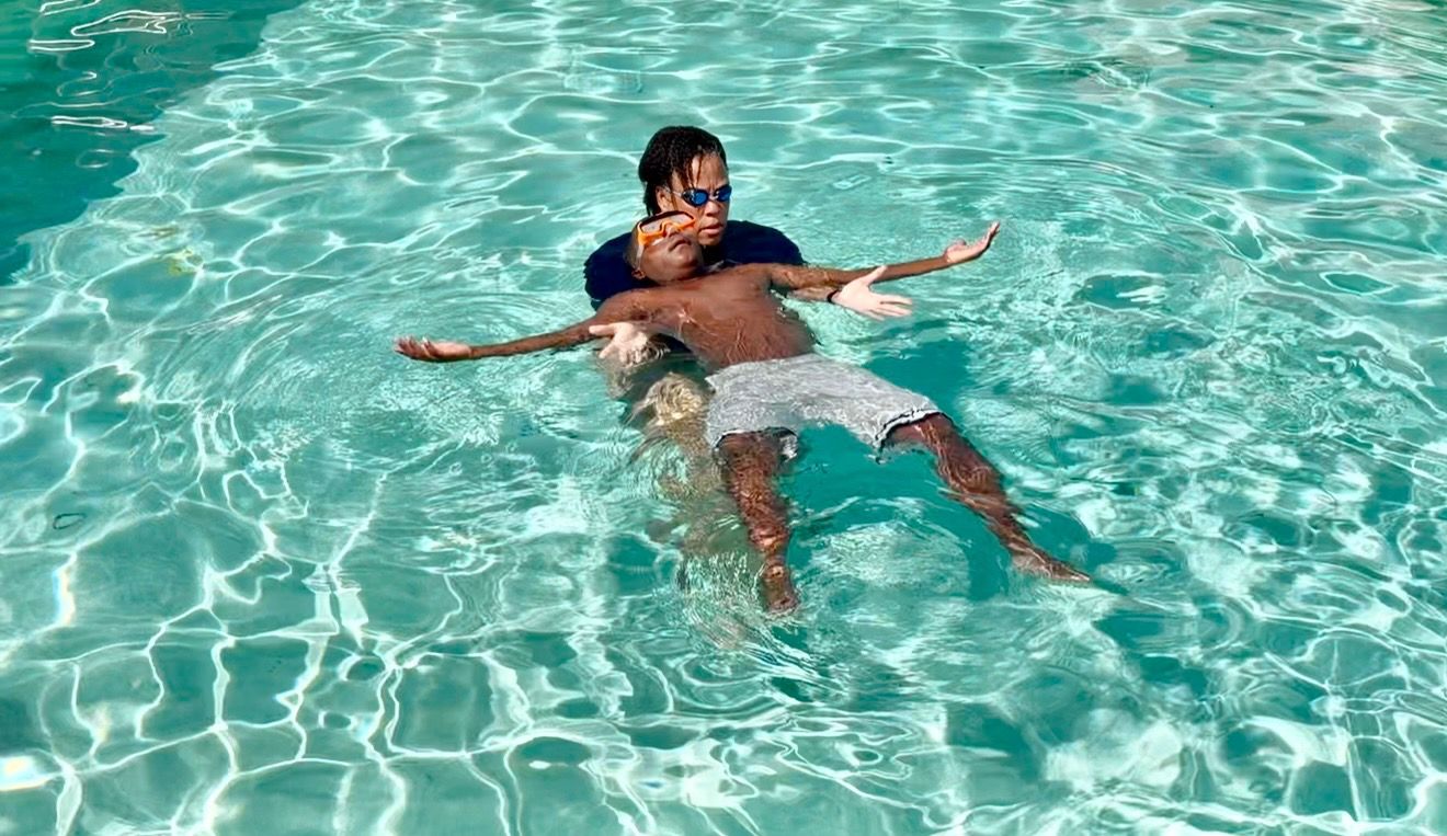 learning to swim in a pool with a swim instructor